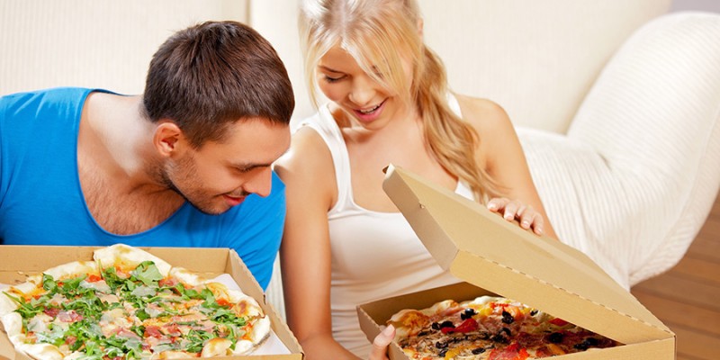 romantic couple eating pizza at home