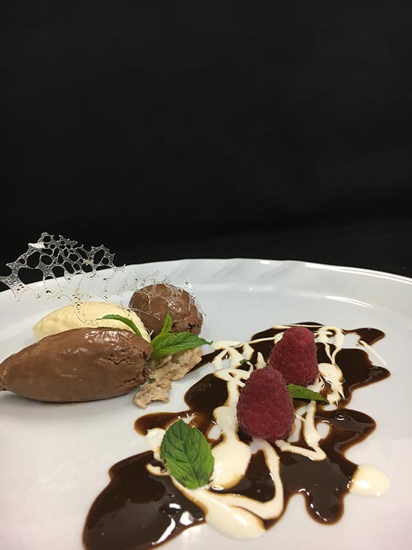 White and dark chocolate mousse with liquorice sauce, ice mint and corn wafers